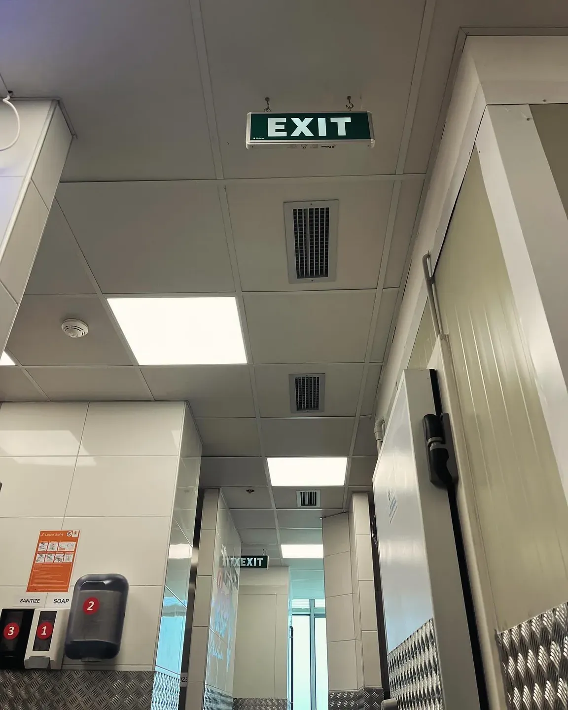 Grila ventilimi të integruara në tavanin e varur të një ambienti zyre