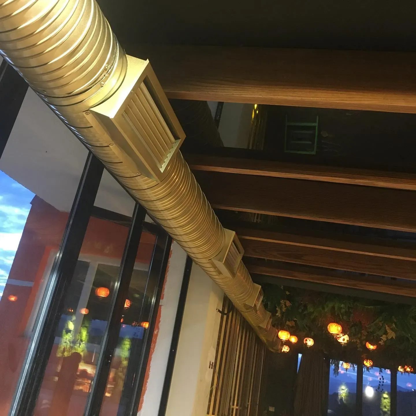 Kanale spirale ventilimi të dukshme në tavanin e një lokali