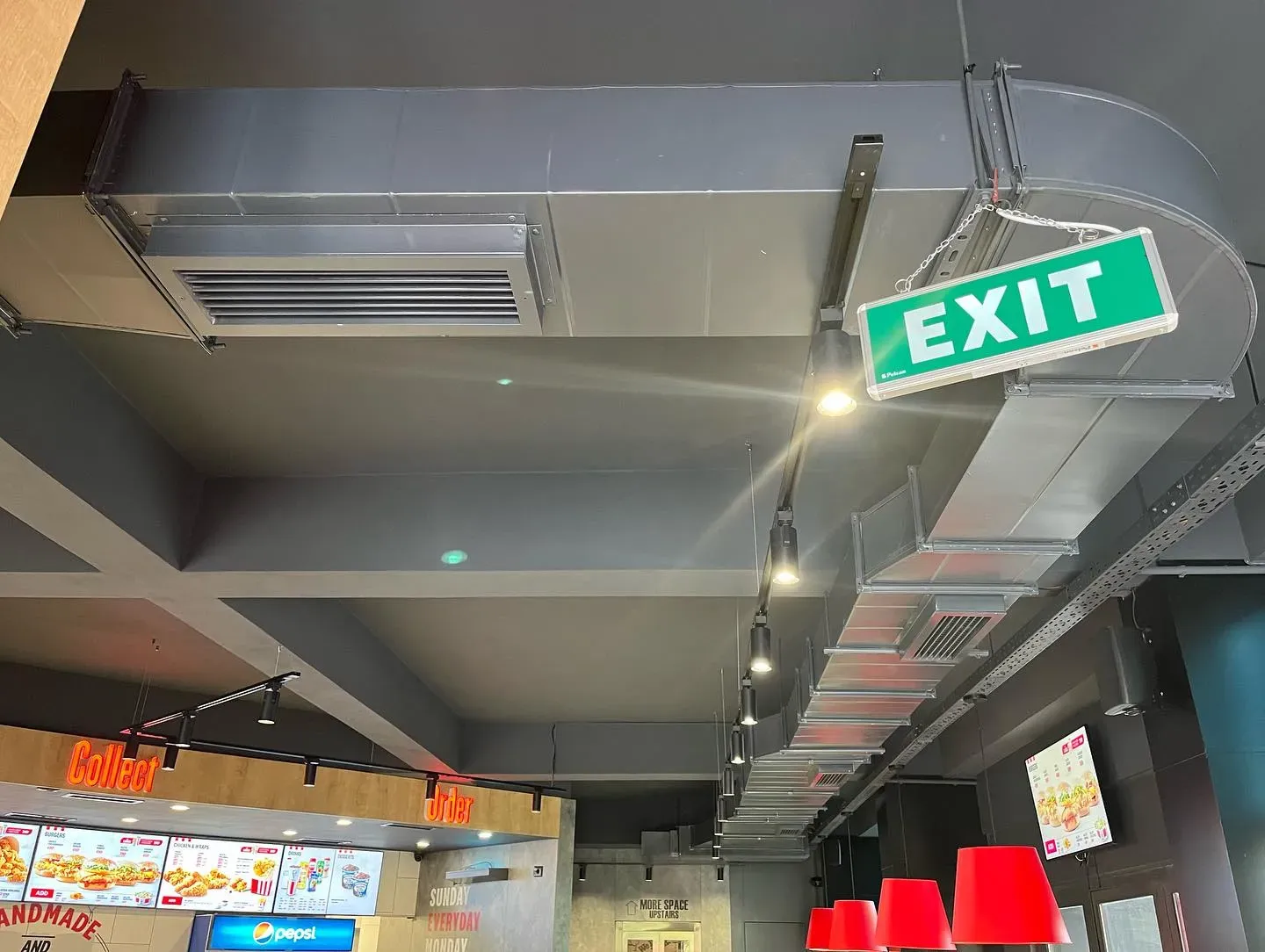 Kanale ventilimi dhe ndriçim teknik në tavanin e një lokali ushqimor