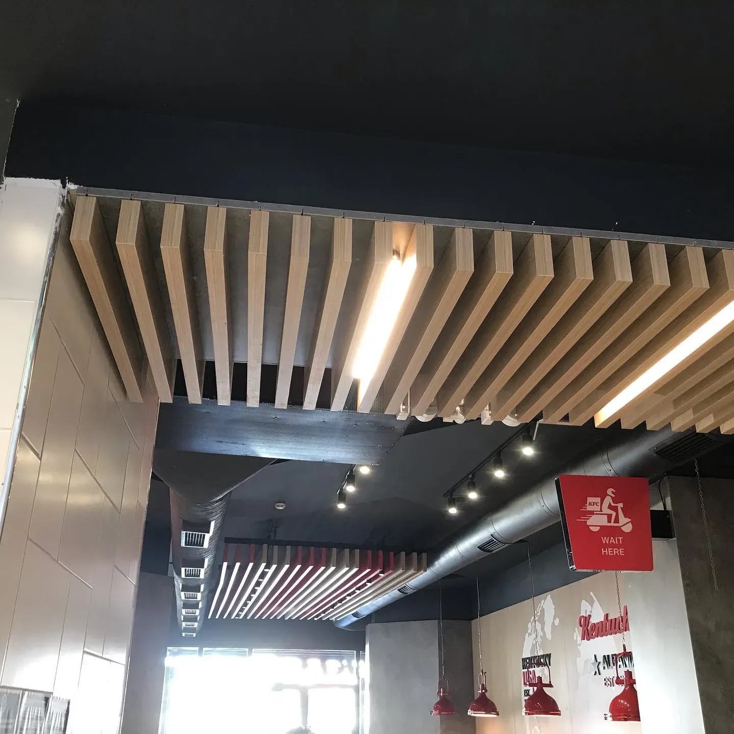 Kanale ventilimi të integruara në tavanin dekorativ të një lokali