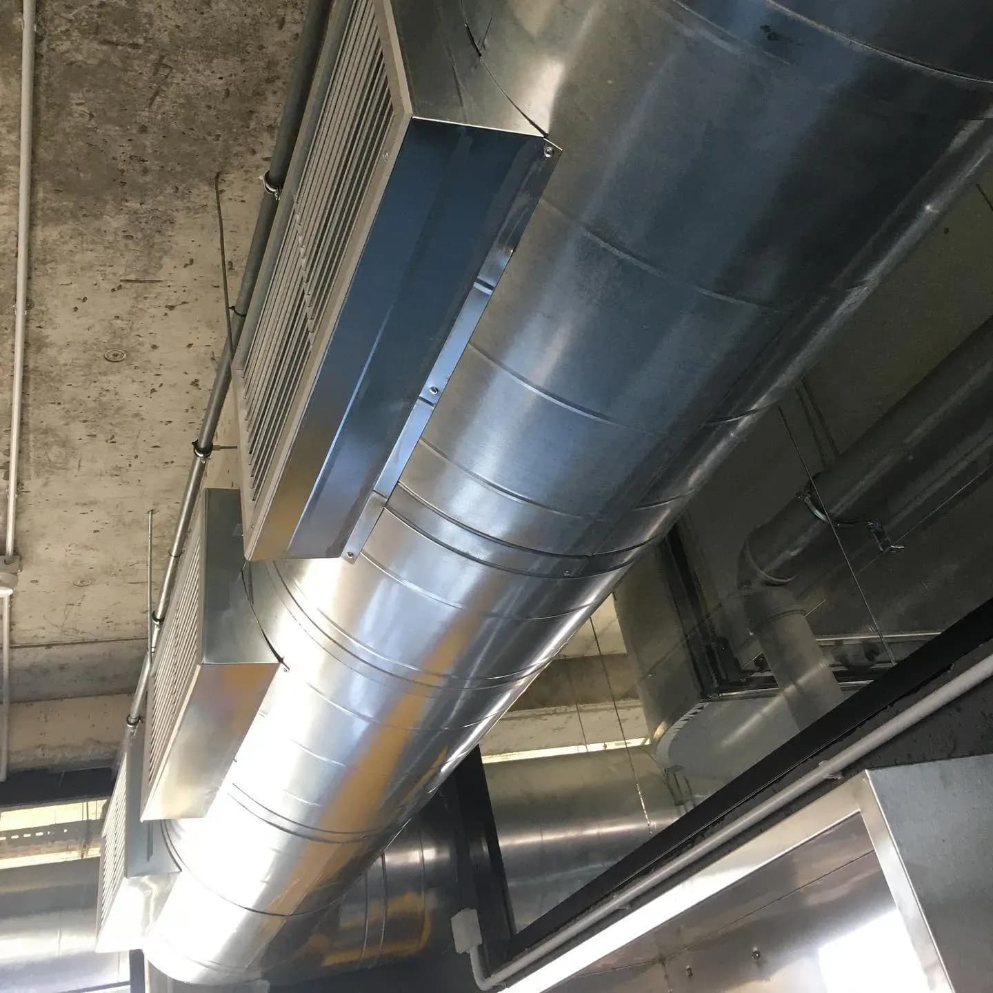 Kanale ventilimi spirale të instaluara në tavanin e një ambienti biznesi në Tiranë