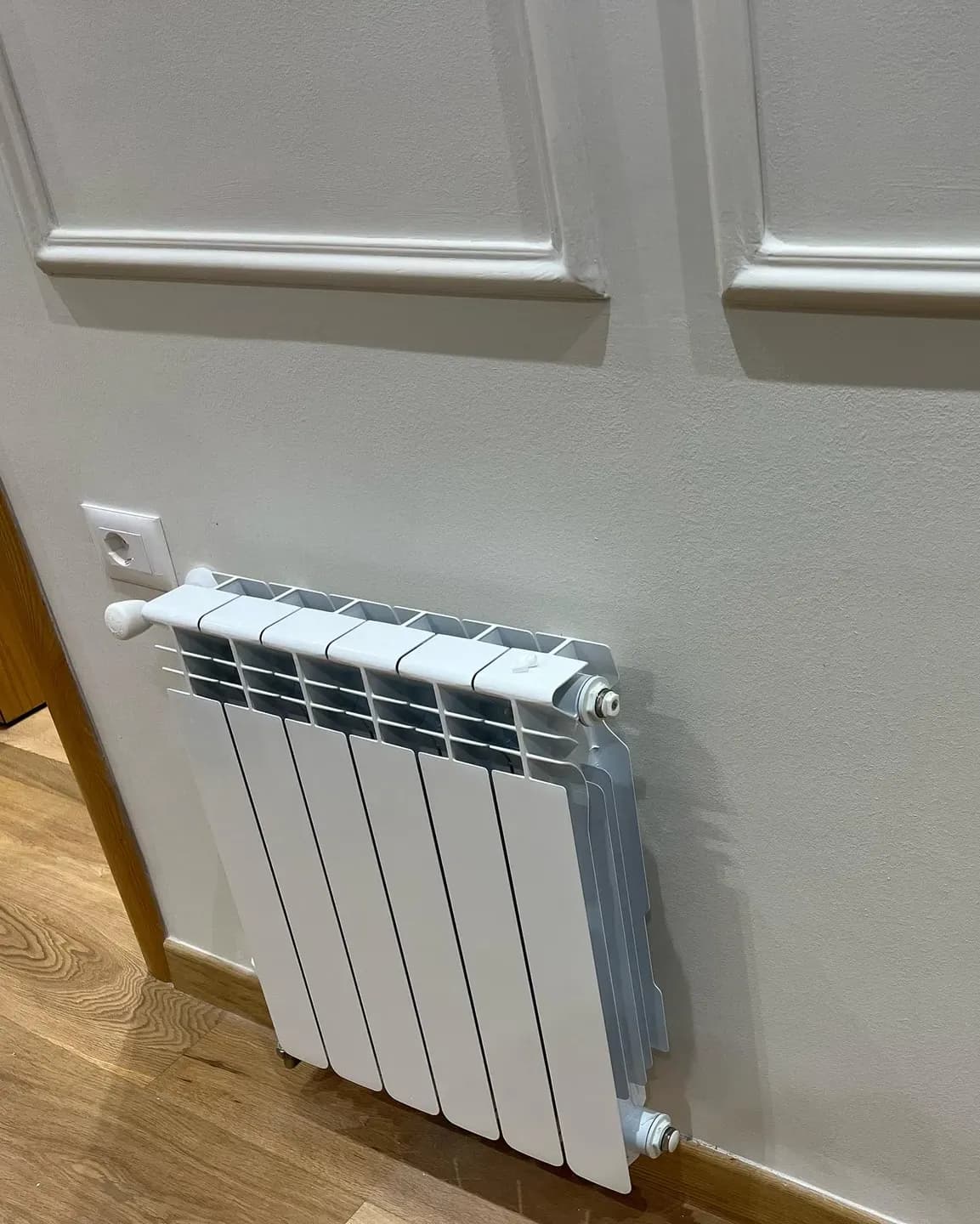 Radiator ngrohjeje i instaluar në një dhomë banimi